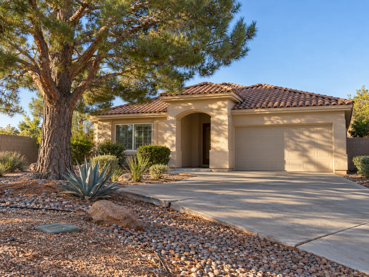Single-storey stucco home in Green Valley, Henderson, NV, shaded by a mature pine over a rock and gravel front yard