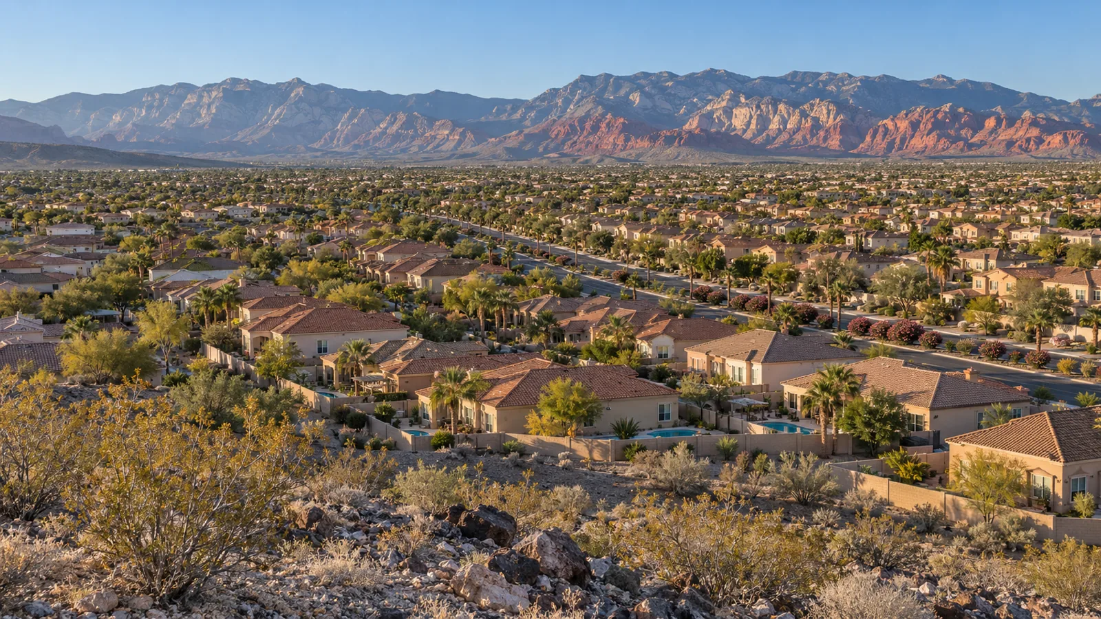 Tile-roofed stucco homes and block walls across the Las Vegas Valley, with the mountains to the west in morning light